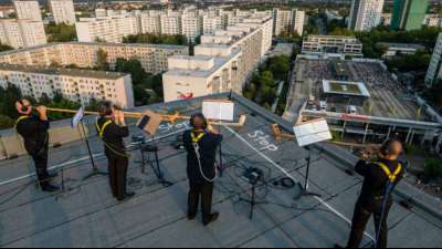 Dresdner Sinfoniker spielen von Hochhausdächern in Plattenbaugebiet