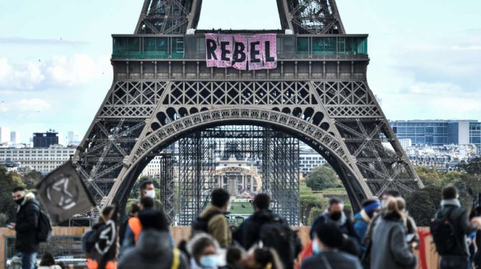 Mitglieder von Extinction Rebellion klettern am Eiffelturm hoch