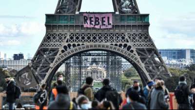Mitglieder von Extinction Rebellion klettern am Eiffelturm hoch