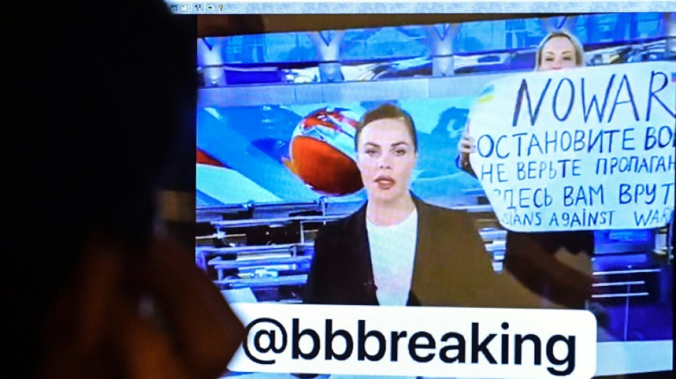 Protester interrupts Russian TV news with anti-war poster